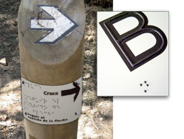 Poste de señalización de ruta con información de donde se encuentra el excursionista y de lo que hay próximamente. Junto a imagen ejemlo del material utilizado (chapas de acero/hierro con altorrelieve y braille)
