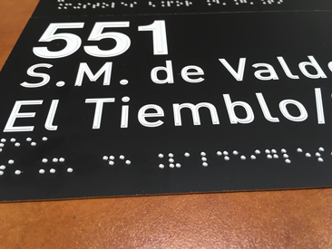Etiqueta con información concreta de una linea de autobús indcando el origen y el destino en altorrelieve y braille