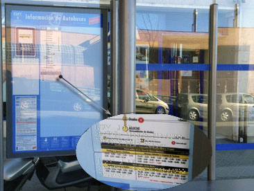 Instalación de las etiquetas adhesivas con información de número, origen y destino de línea instaladas en las marquesinas de la red de autbuses de la EMT