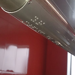  Placa metálica instalada en los pasamanos de la estación de Paco de Lucia con texto Braille